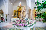 一座布置精美的教堂祭坛，设有雕像和鲜艳的花卉装饰，展现了信仰与传统的融合