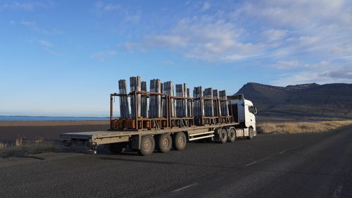 Free A truck carrying metal cargo on a scenic Icelandic road with mountains in the backdrop. Stock Photo