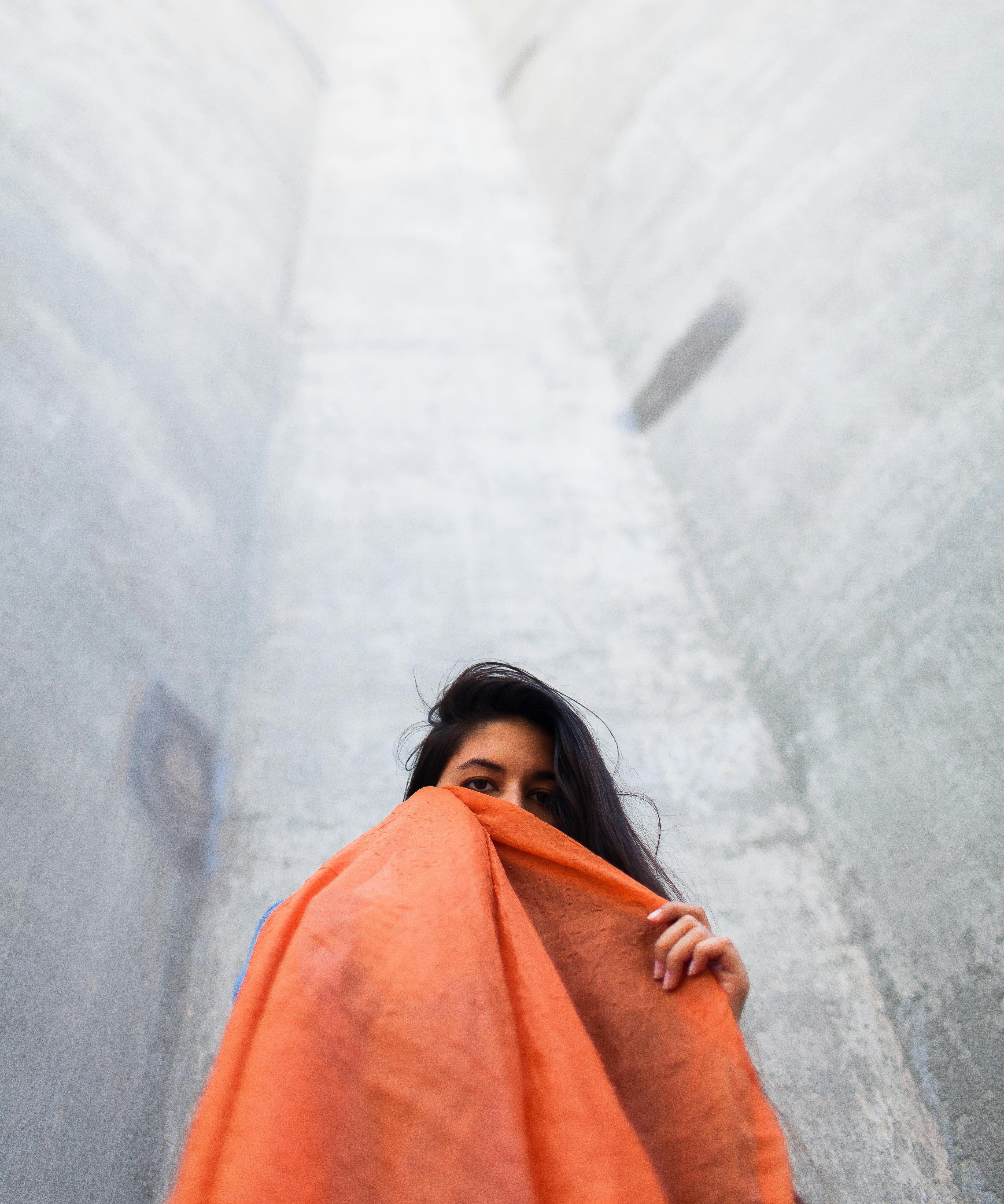 woman holding orange scarf