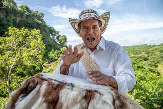 一位年长的哥伦比亚男子在郁郁葱葱的乡间户外奋力敲击着传统鼓