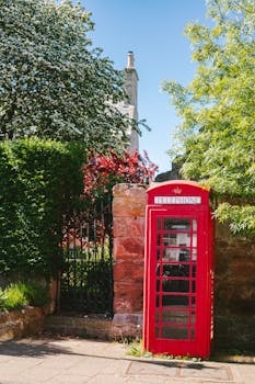 Scenic view of a red telephone box amidst greenery in Avoch, Scotland.