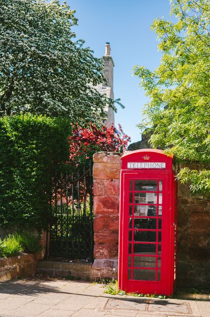 Scenic view of a red telephone box amidst greenery in Avoch, Scotland.