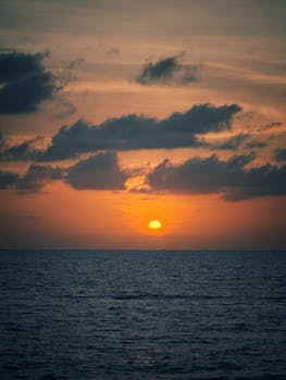 Beautiful sunset over the ocean with vibrant colors and dramatic clouds.