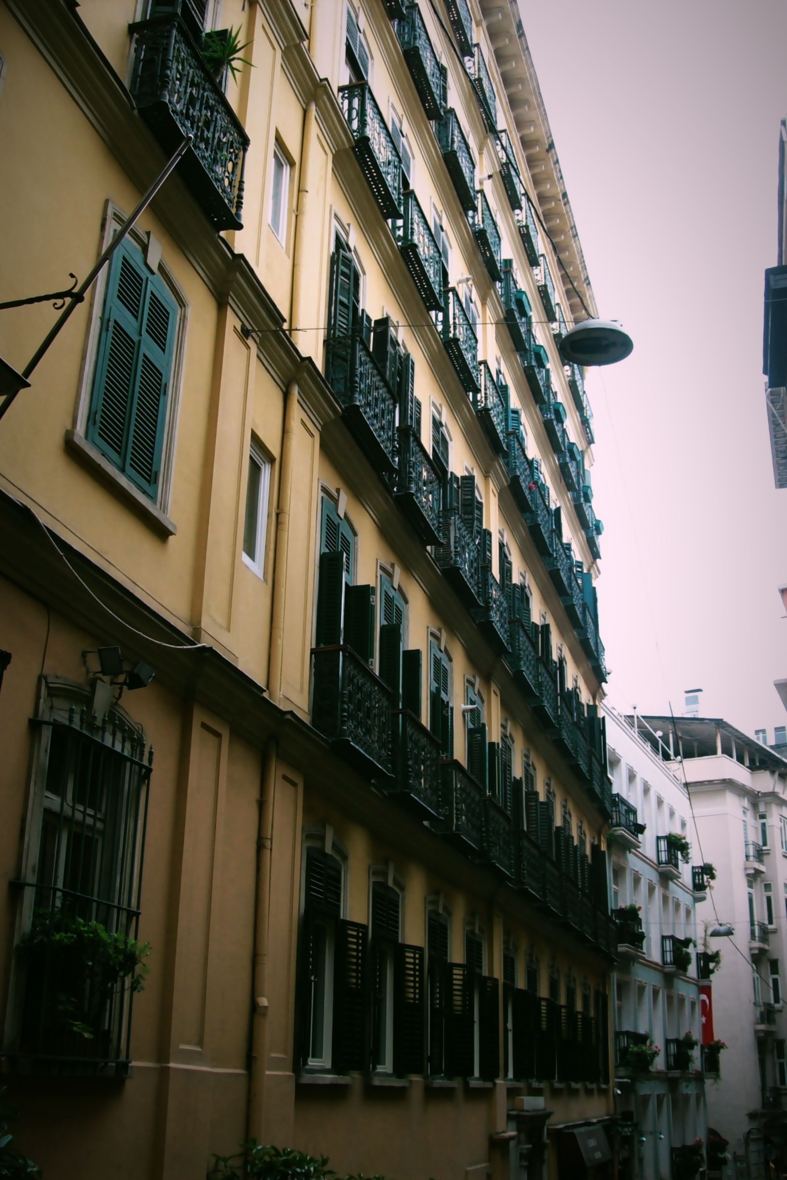 A picturesque view of an old architectural street lined with historical buildings displaying classic iron balconies.
