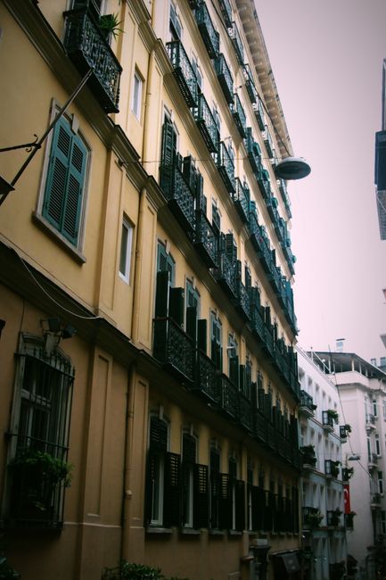 A picturesque view of an old architectural street lined with historical buildings displaying classic iron balconies.