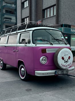 Retro pink van parked on an urban street, showcasing classic automotive design.
