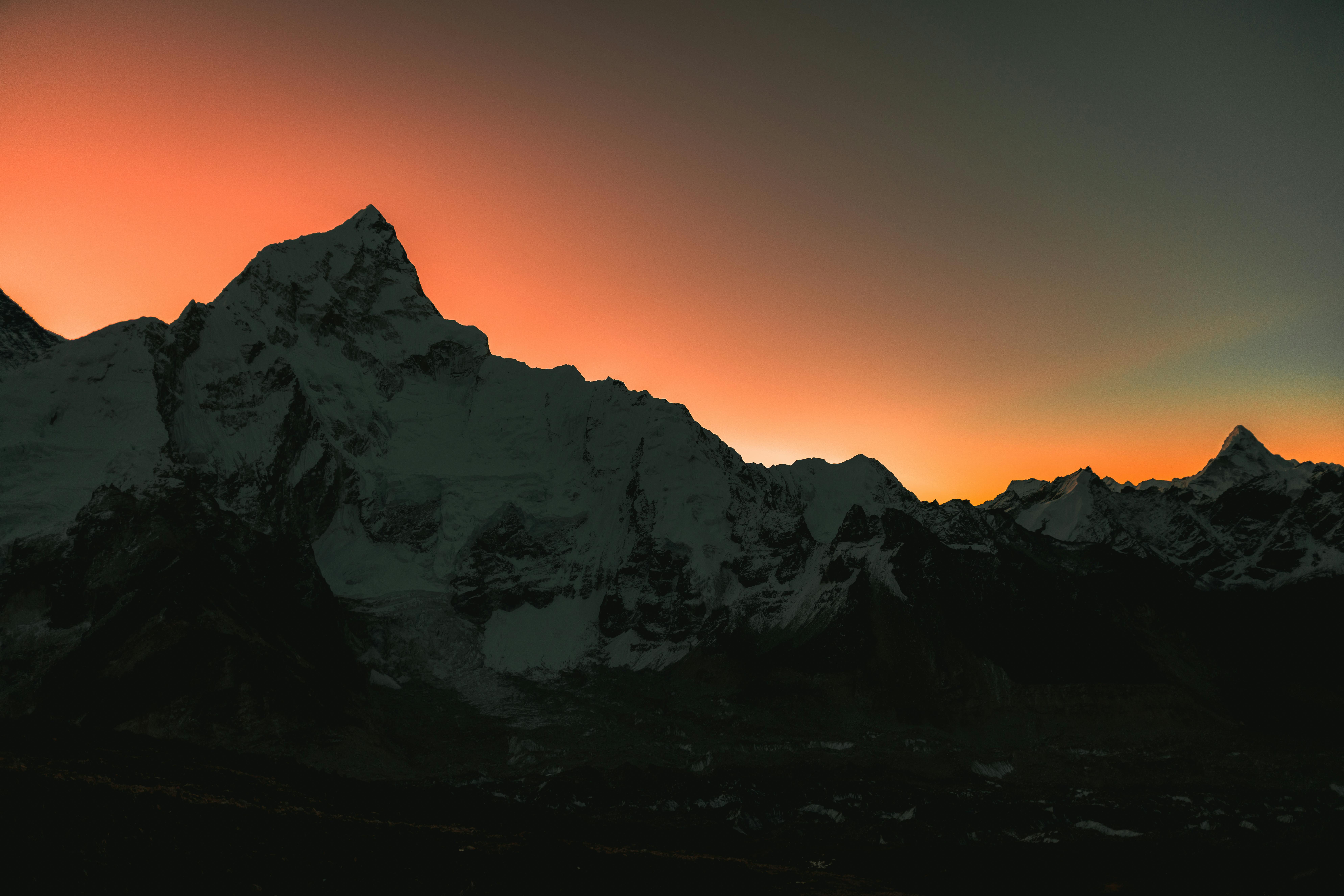 Dramatic silhouette of the Himalayas during a vivid sunset in Nepal's mountainous landscape.