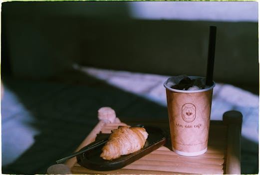 Artistic shot of coffee and croissant at Hơn Nữo Café, perfect for cozy mornings.