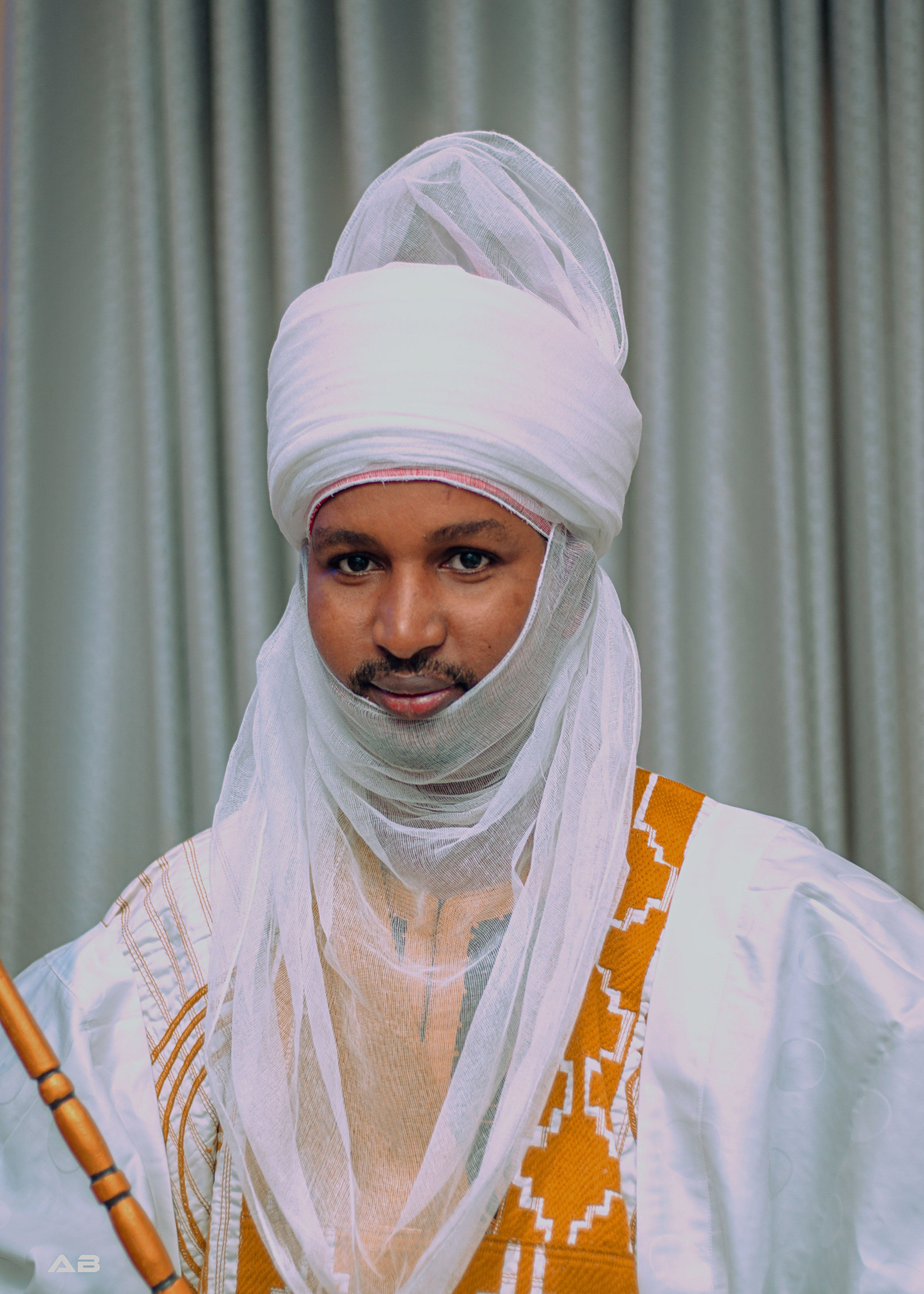 Portrait of a man in traditional African attire and turban, embodying cultural heritage.