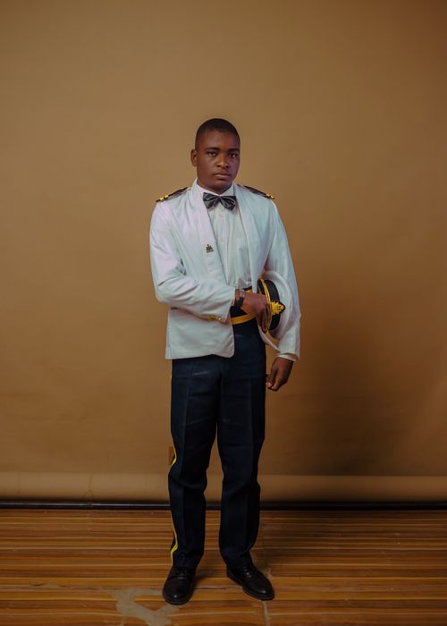 Free Portrait of a man in formal military attire standing indoors against a neutral background. Stock Photo