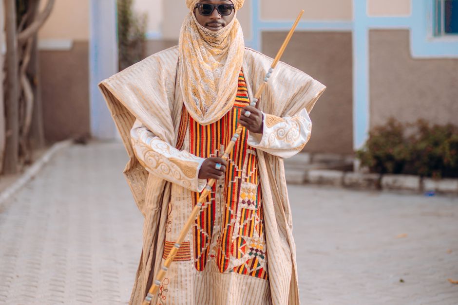 Man in traditional Central African ceremonial attire holding an ornate walking staff — ibogaine derives from the iboga root used for centuries in the Bwiti tradition of Central Africa