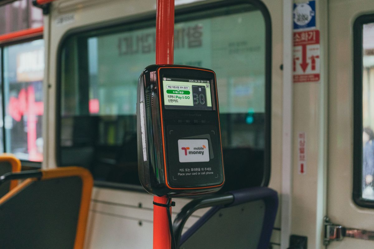Close-up of a T-money card being tapped on a transit card reader in Seoul