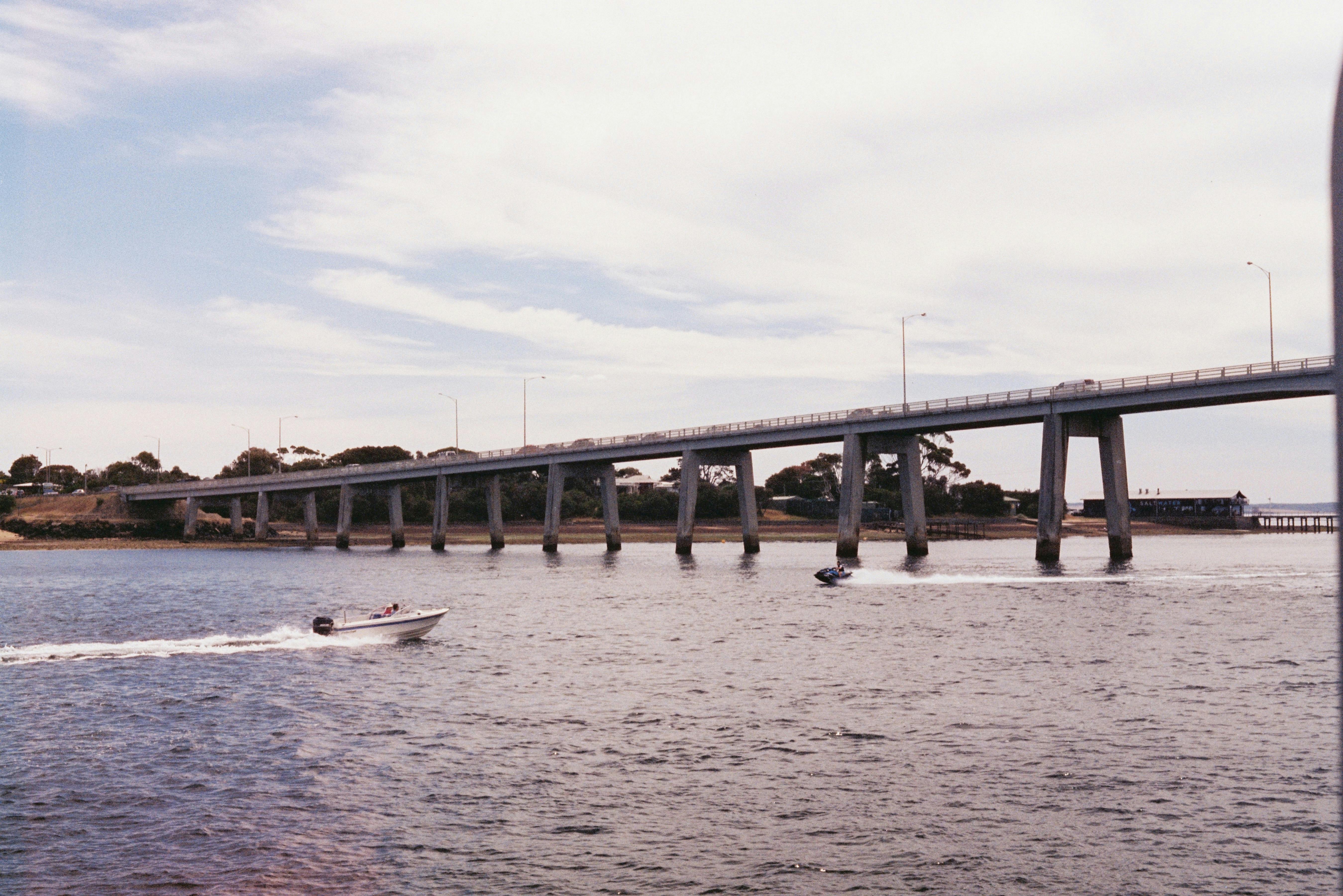 Beautiful daytime scene of boats passing under San Remo Bridge in Victoria, Australia.