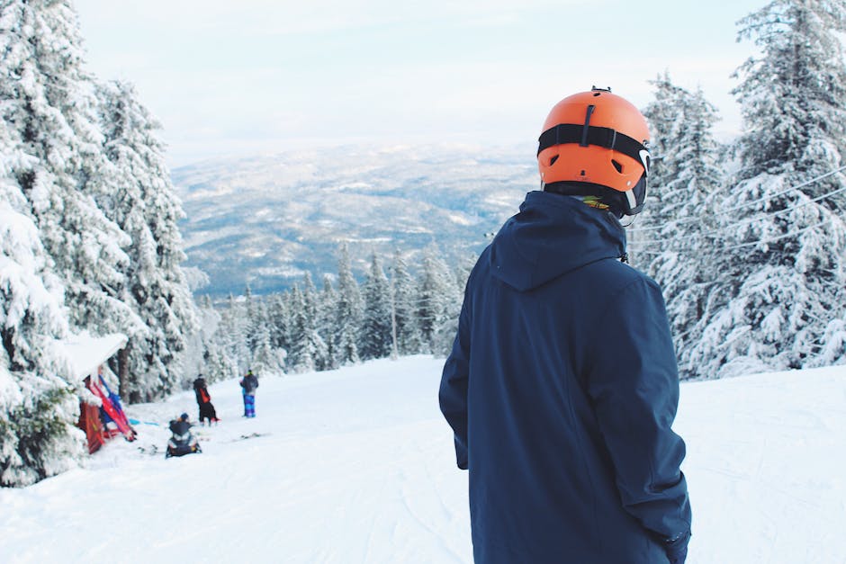 Man Standing on Snow Covered Mountain