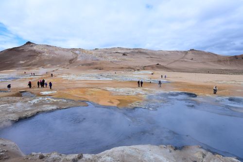 Free Visitors at Hverir geothermal area, Iceland, admiring the unique landscape and hot springs. Stock Photo