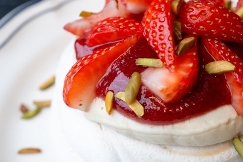 Free Close-up of pavlova topped with strawberries, pistachios, and berry sauce. Stock Photo