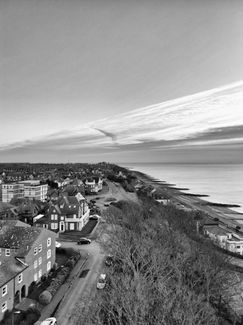 Free Aerial view of a coastal town with residential houses and a coastline in black and white. Stock Photo