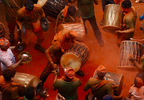 Energetic drummers at Sindoor Jatra festival in Madhyapur Thimi, Nepal, celebrating with vibrant colors and traditional music.