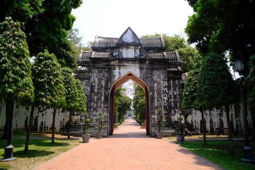 Free Explore the scenic beauty of a historic archway flanked by lush greenery under a bright day. Stock Photo