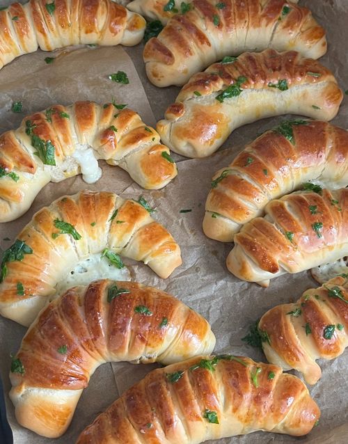 Free Tasty homemade crescent rolls garnished with fresh herbs, perfect for any meal. Stock Photo