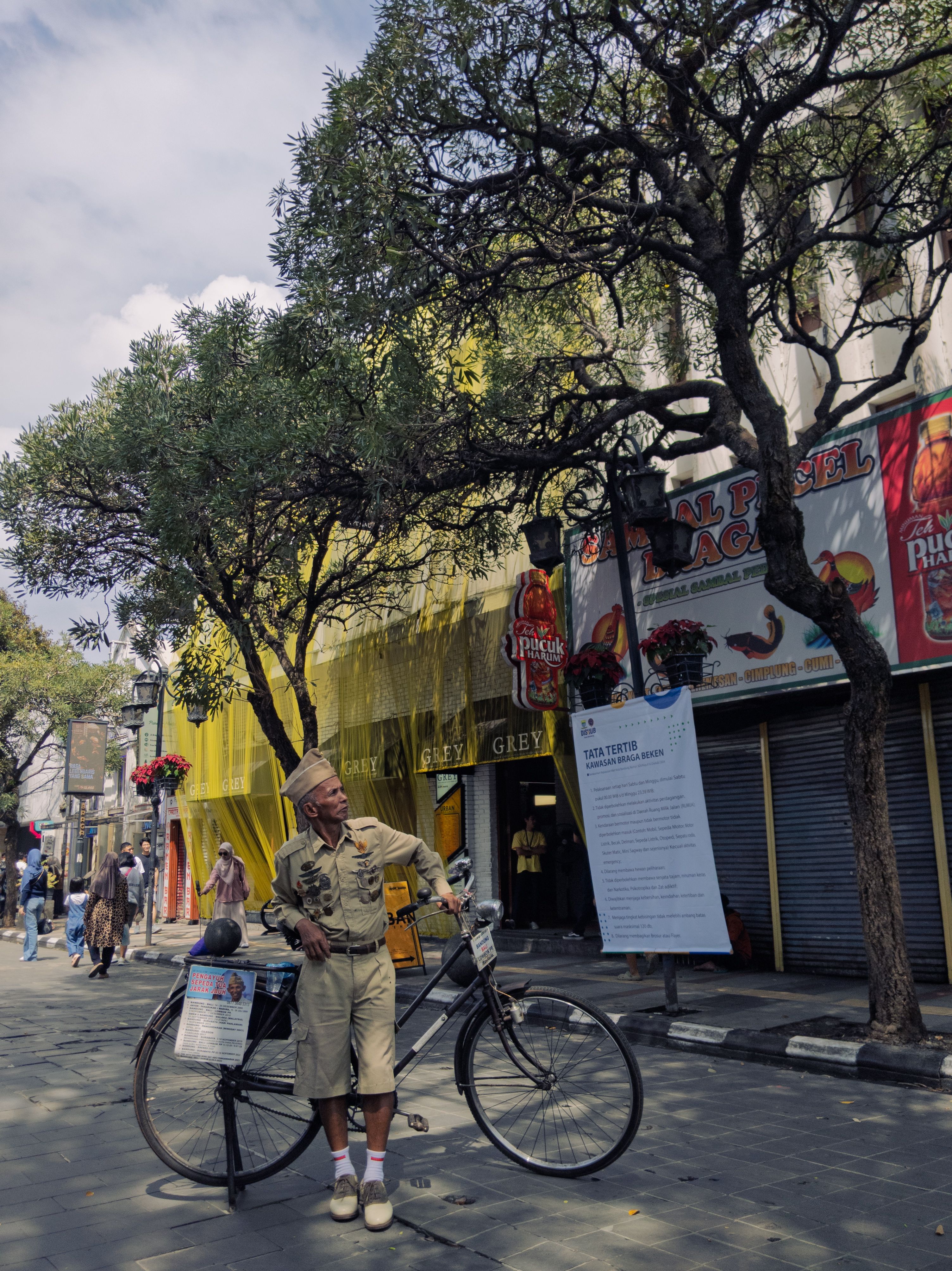 Vintage Dressed Man with Bicycle in Bandung Street
