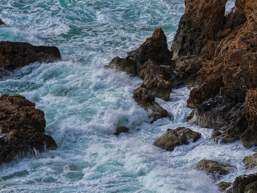 Free Waves crash against rugged coastal rocks, showcasing the power of nature's beauty and drama. Stock Photo