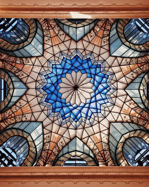 Free Captivating geometric stained glass ceiling with blue and brown tones. Stock Photo