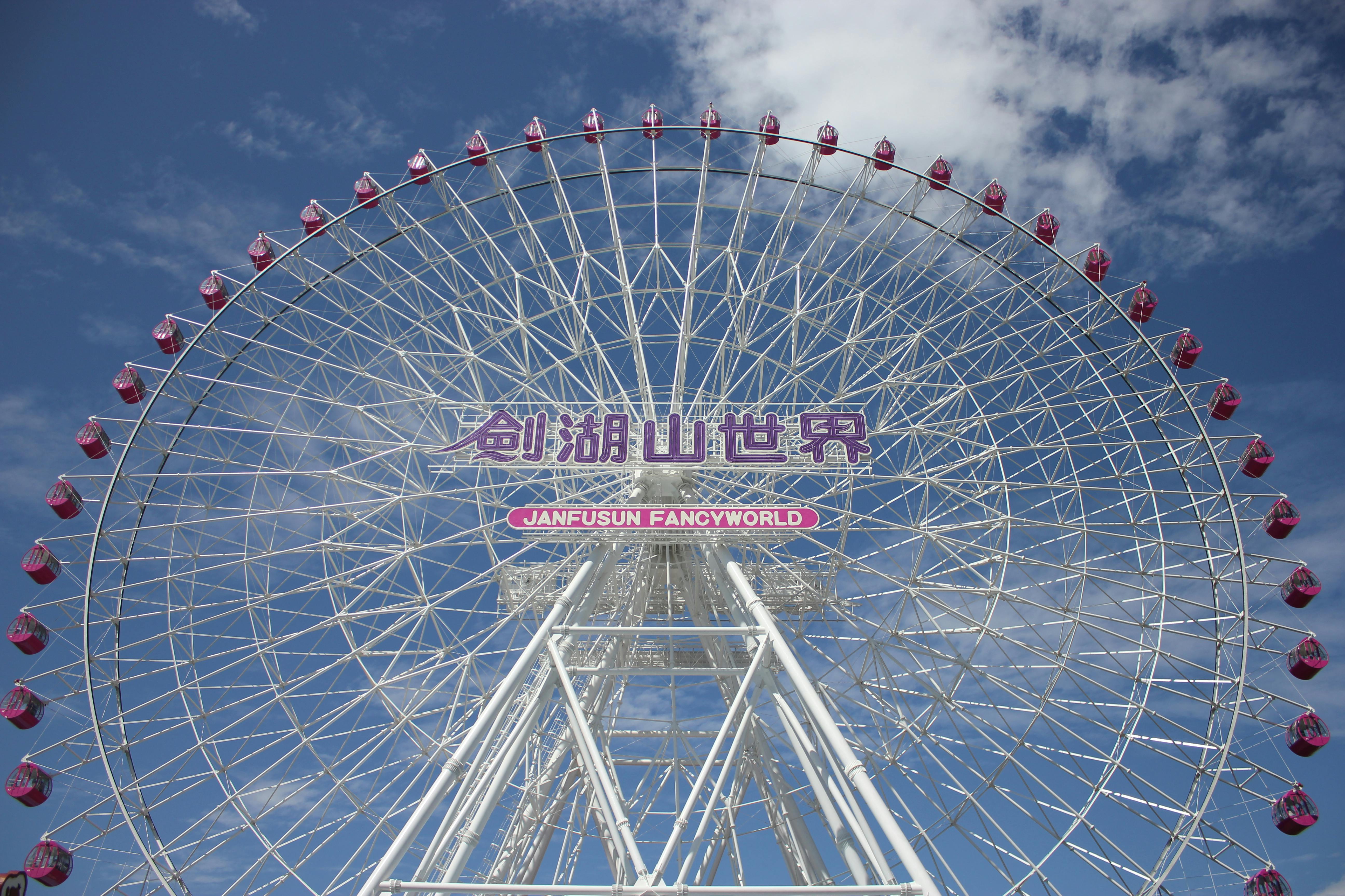 Giant Ferris wheel at Janfusun Fancyworld against a bright blue sky, offering a stunning view.