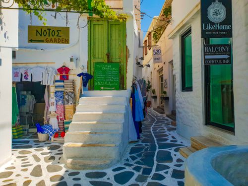 Free Picturesque alley in a Greek village showcasing local shops and vibrant architecture. Stock Photo