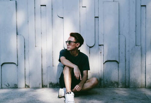 Man Sitting Beside Wall