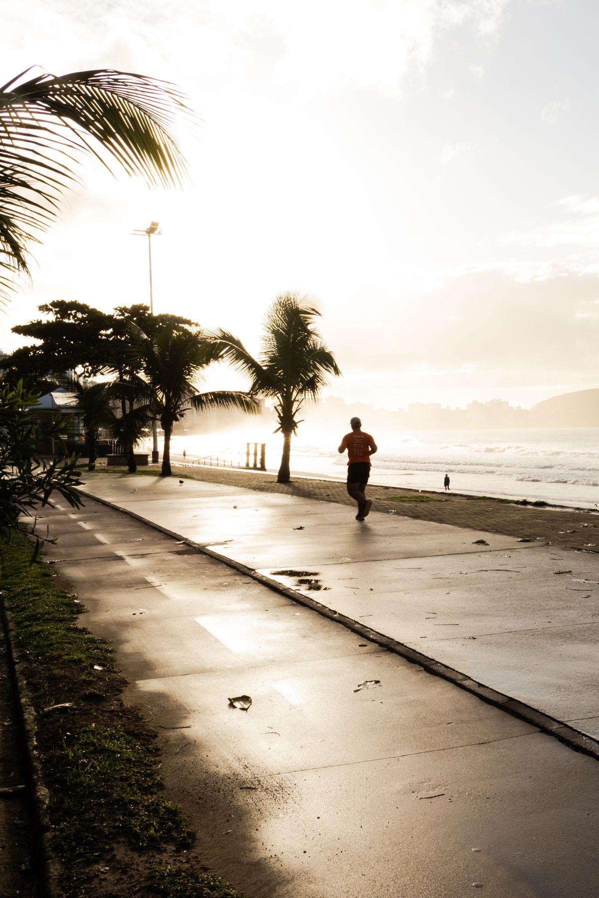 Runner jogging along a beachfront path at sunrise during a race-week shakeout