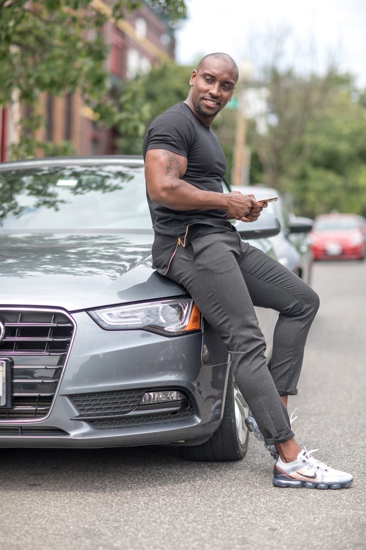 Man Sitting On The Hood Of A Car