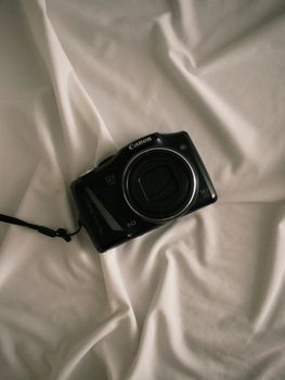 A vintage camera resting on white fabric, evoking nostalgia and classic photography.