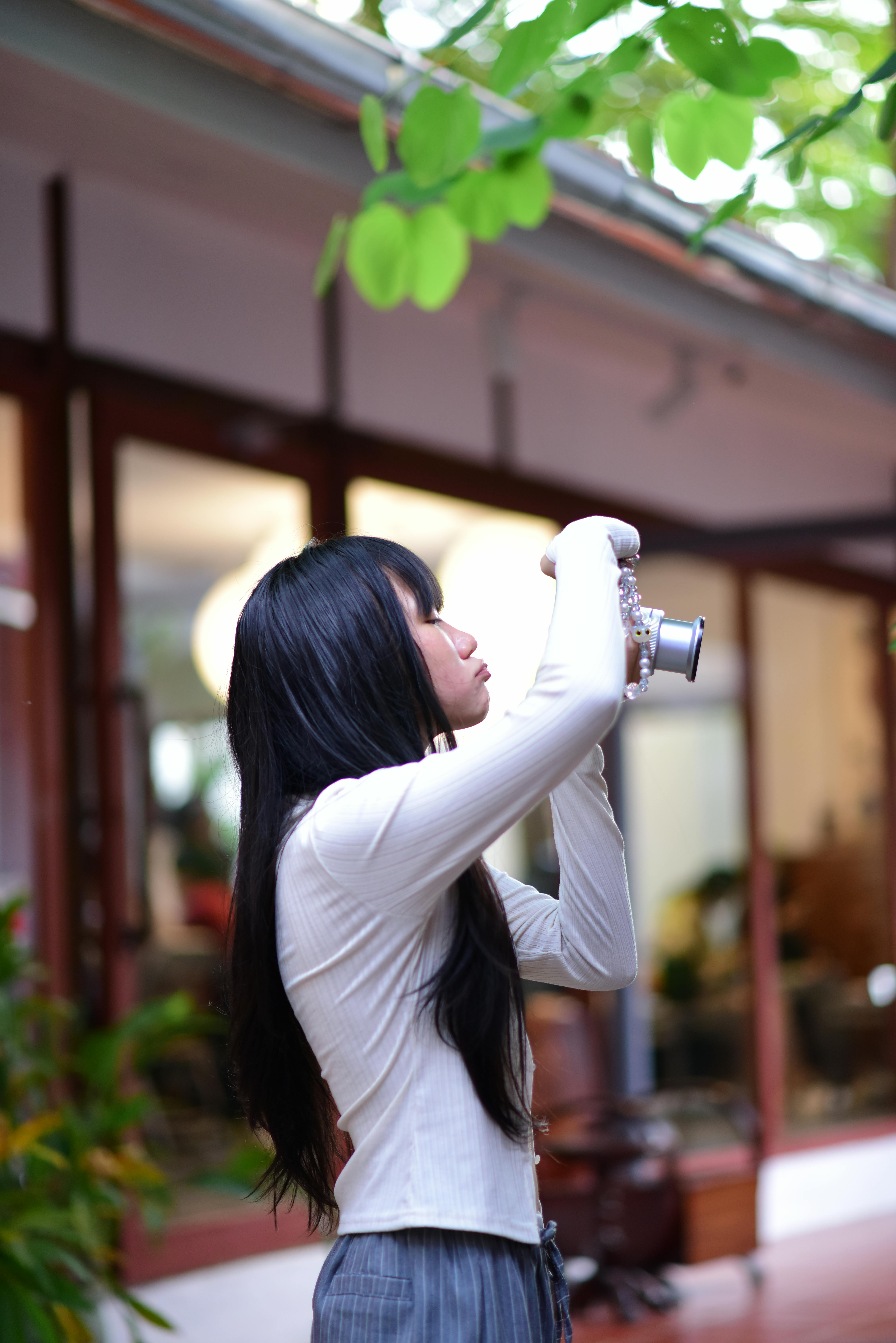 Free Young woman using a vintage camera outdoors, embracing photography and creativity. Stock Photo