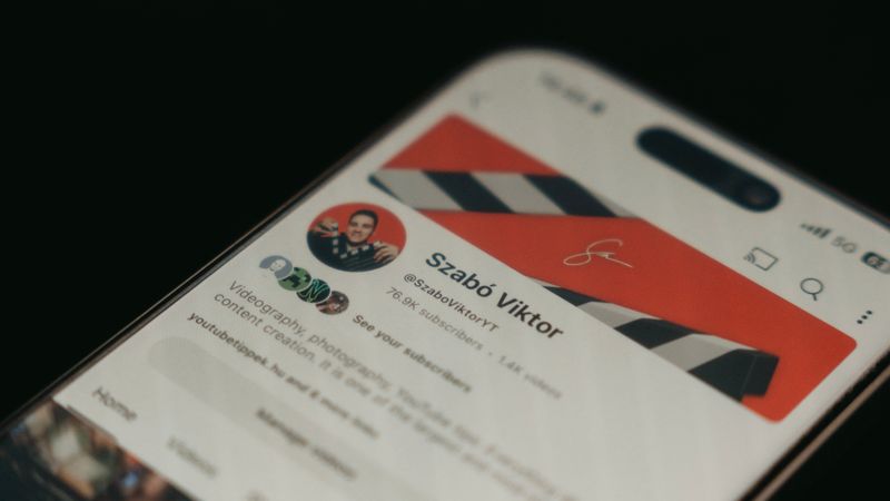 A smartphone showing a YouTube channel page screenshot in focus with blurred background.