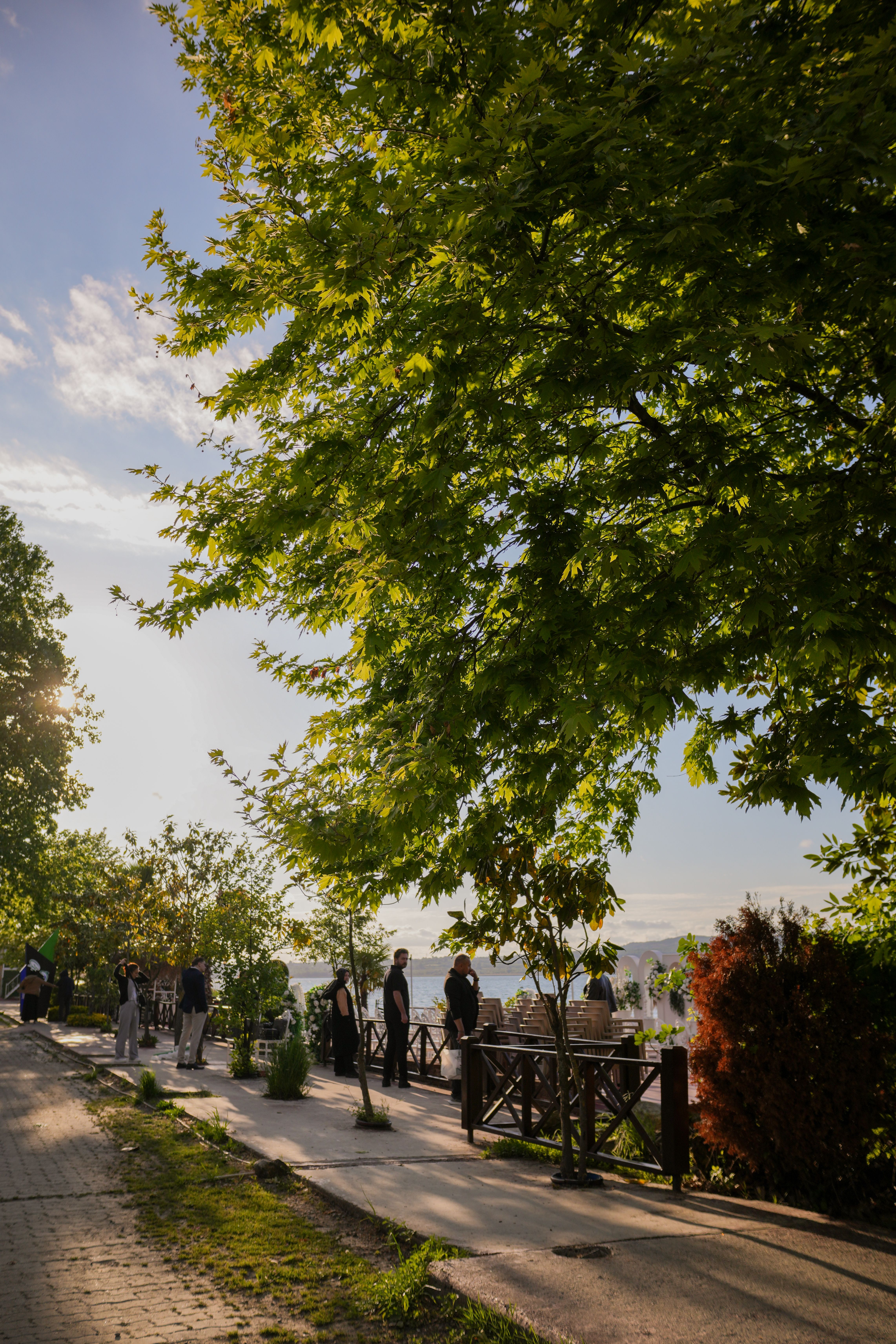 Scenic Riverside Walkway with People Strolling · Free Stock Photo