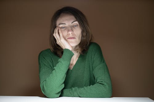 Femme En Pull Vert Tenant Sa Joue