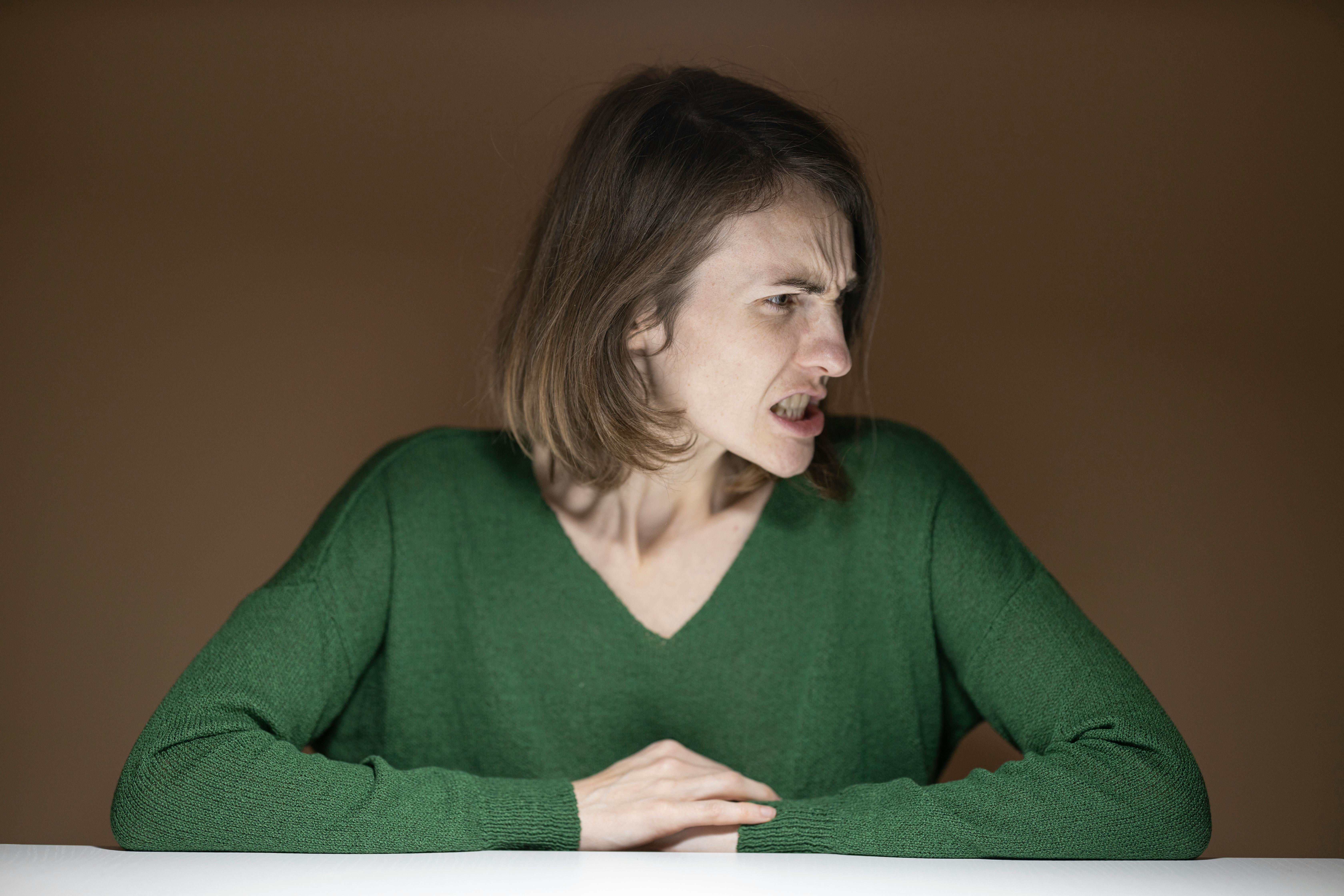 Angry woman leaning on a table. | Photo: Pexels