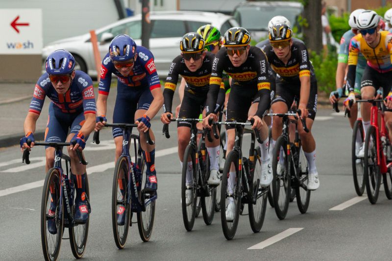 Group of cyclists racing on city streets during a competitive cycling event.