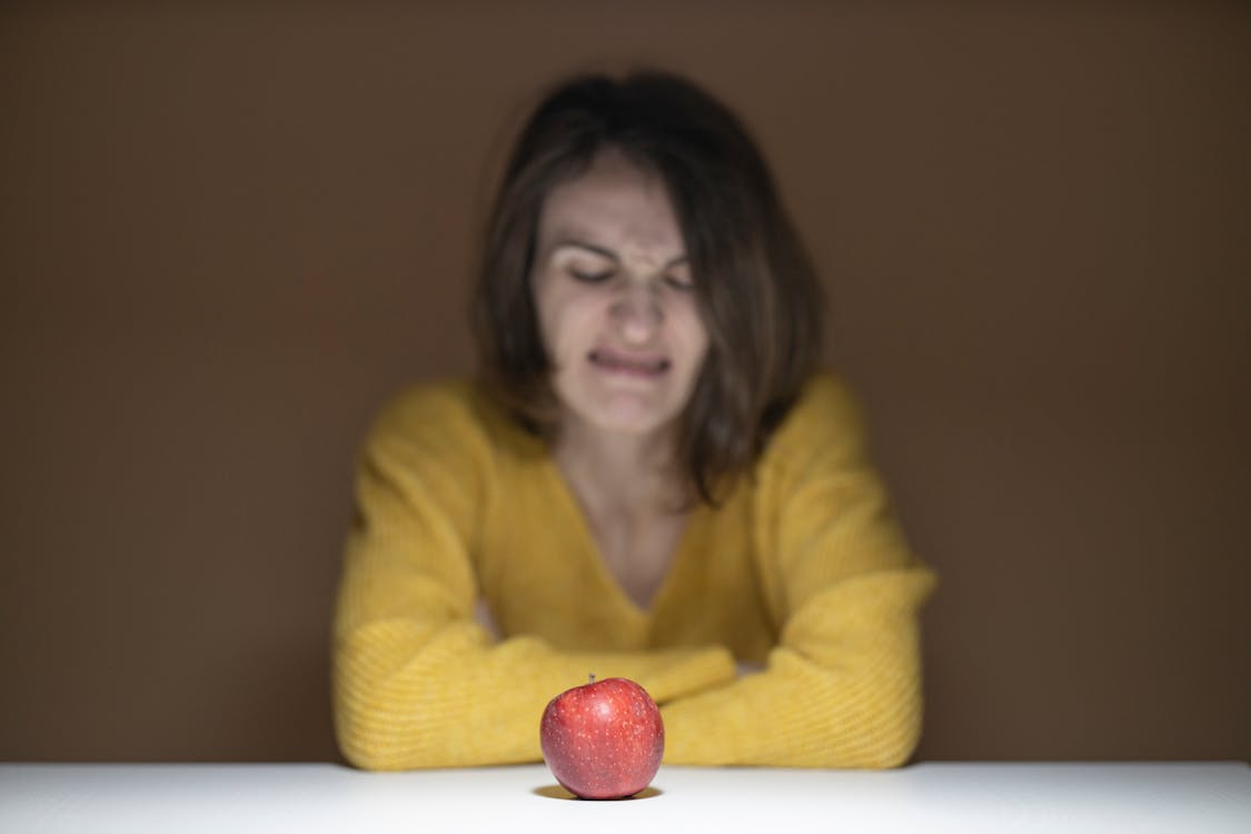 Free Woman Disgusted Looking at the Apple Stock Photo
