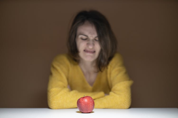 Woman Disgusted Looking At The Apple