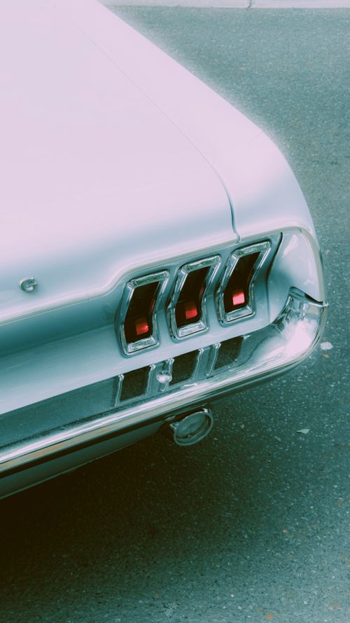 Free Vintage car tail lights on a Berlin street evoke timeless elegance and automotive history. Stock Photo