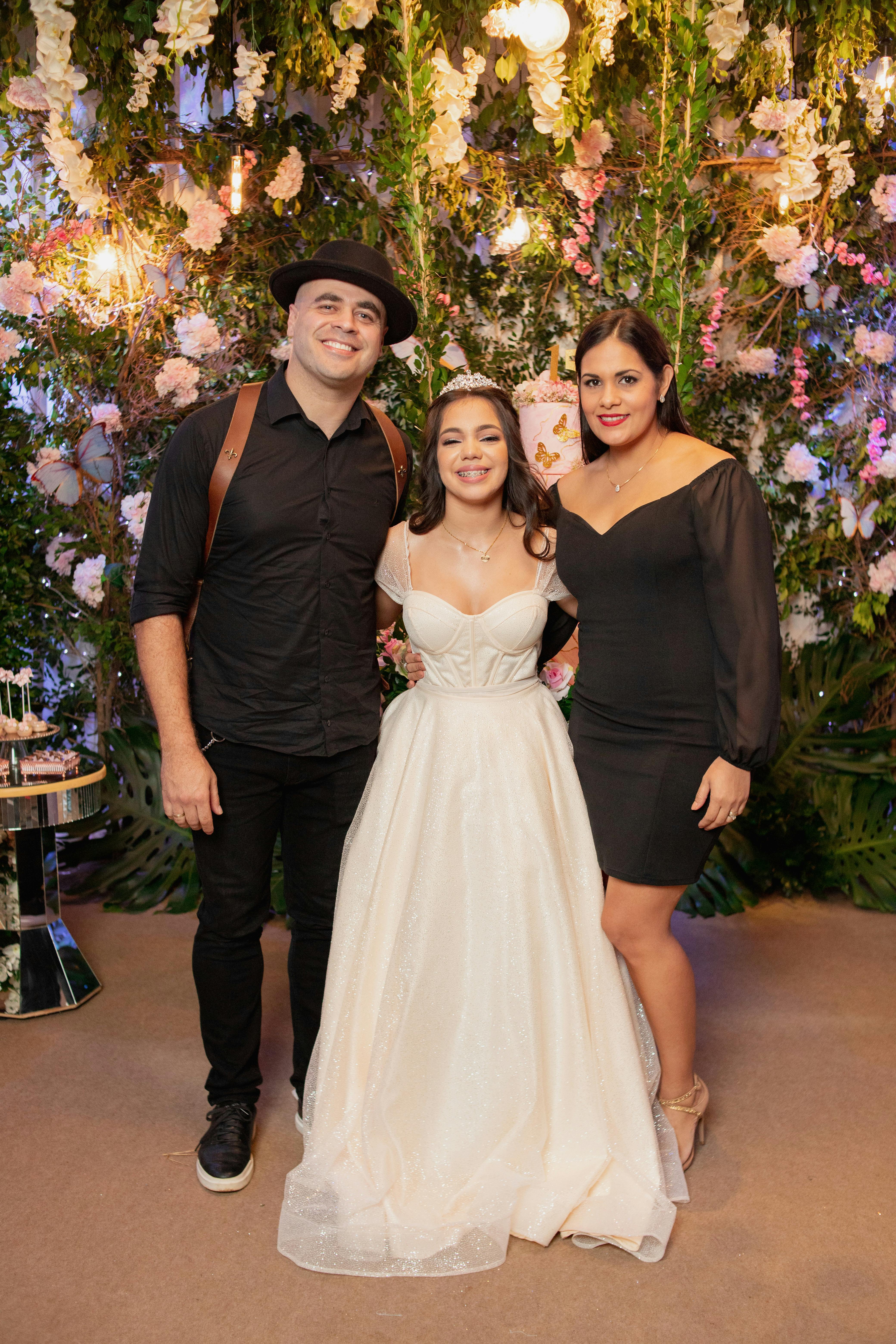 Three elegantly dressed people posing at a sophisticated event.