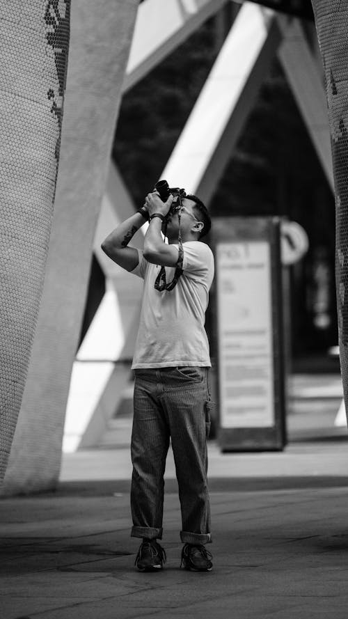 Grayscale Photo of Man Taking Picture Using a Dslr Camera