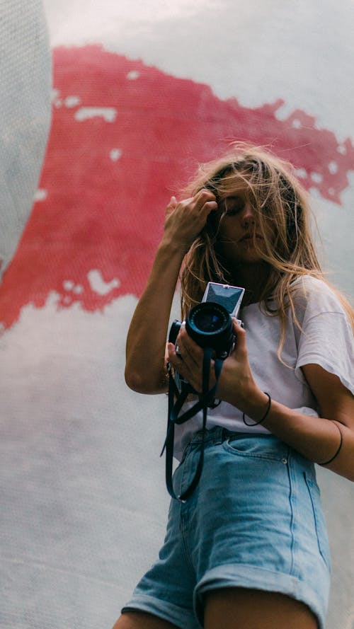 Fotografia Ad Angolo Basso Di Una Donna Che Porta Una Fotocamera Dslr