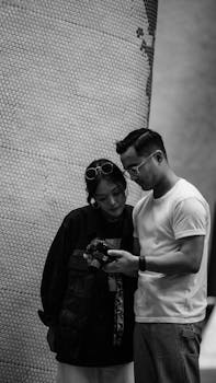 两个朋友在查看相机屏幕上的黑白照片时，分享了一个坦诚的时刻