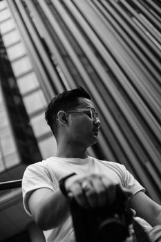 城市建筑背景中戴眼镜男士的时尚单色肖像