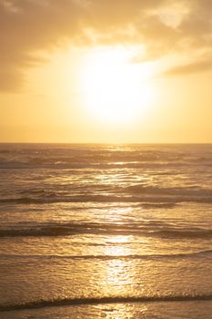 A breathtaking view of the golden sun setting over the tranquil ocean waves, capturing the essence of calm and serenity.