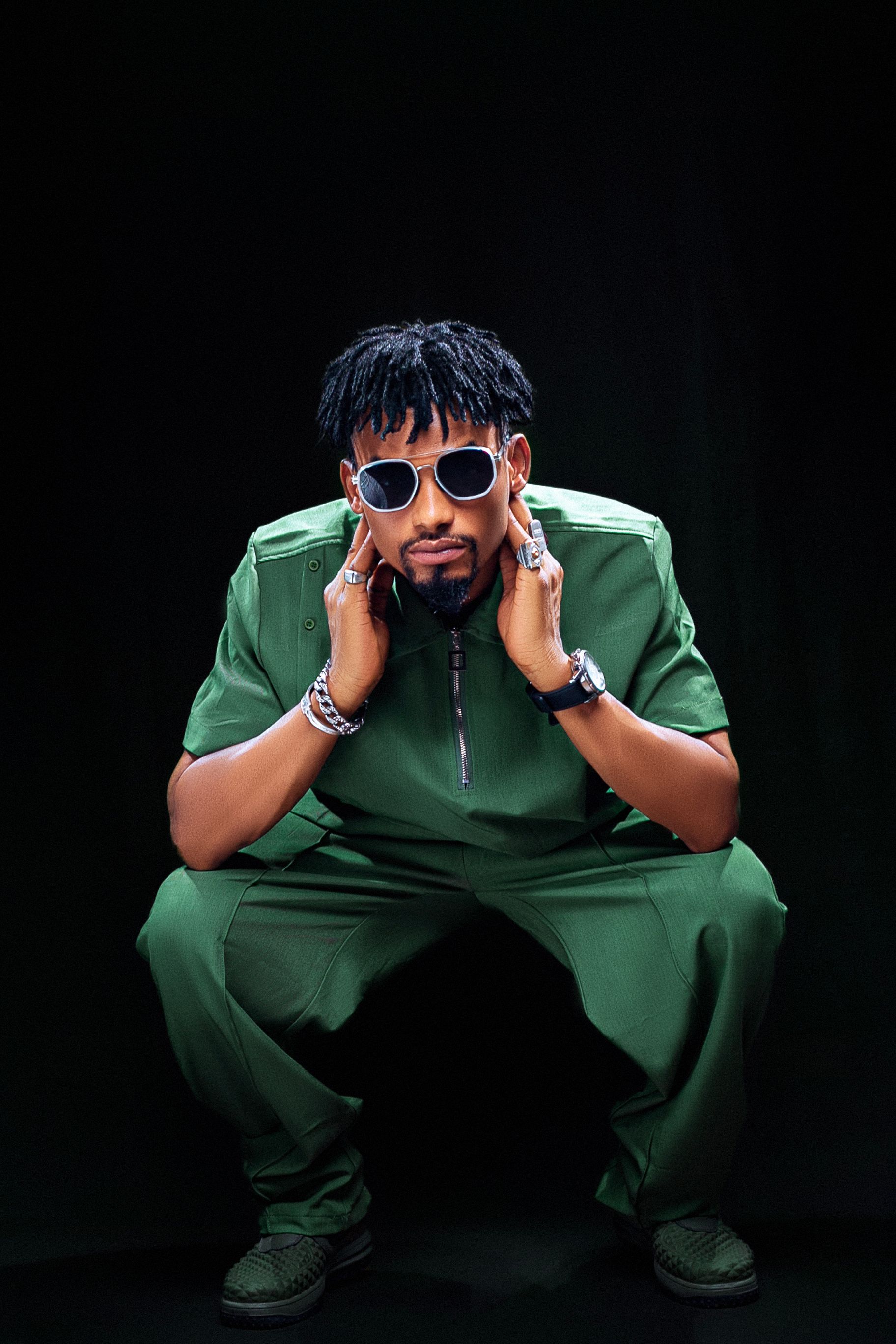 Trendy African male fashion model posing in studio with sunglasses.