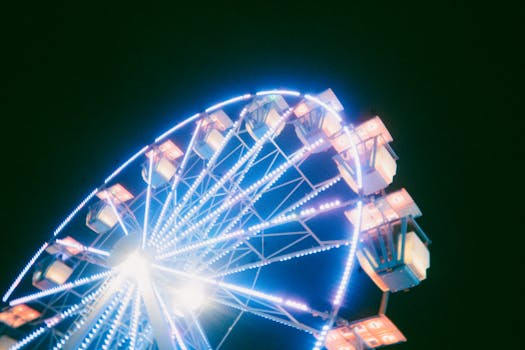 A colorful ferris wheel glowing at night provides a lively carnival atmosphere.